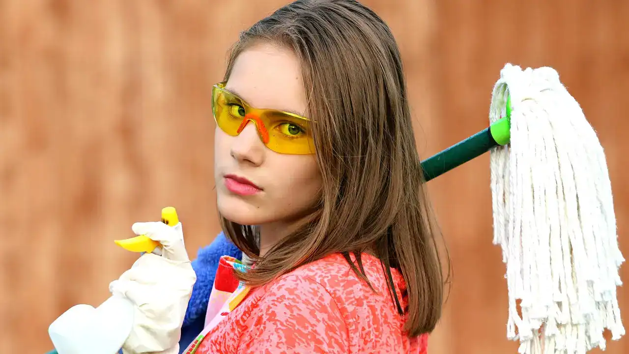 Girl carrying a mop to start cleaning